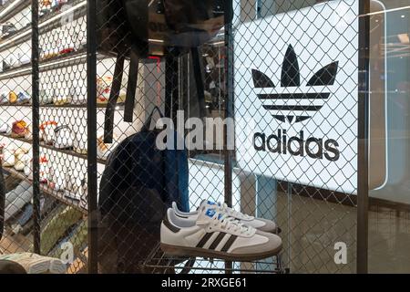 Enseigne publicitaire de marque Adidas et baskets à l'intérieur d'un magasin de chaussures. Adidas néon magasin signe dans la vitrine. Minsk, Biélorussie, 18 septembre 2023 Banque D'Images