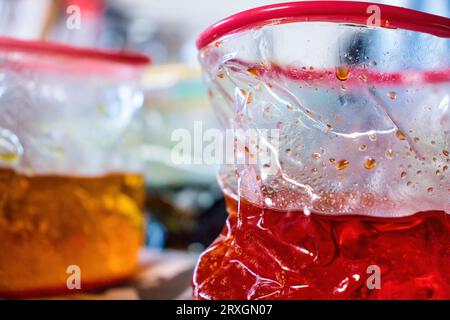 Eau avec colorant pour les œufs de Pâques dans des gobelets en plastique collapsibles. Banque D'Images