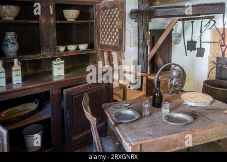 Intérieur de chalet du 19e siècle avec commode antique et table au musée de la vie rurale wallonne à Saint-Hubert, Luxembourg, Ardennes belges, Belgique Banque D'Images