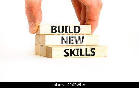 Construire un nouveau symbole de compétences. Mot concept construire de nouvelles compétences sur le beau bloc de bois. Main d'homme d'affaires. Belle table blanche fond blanc. Entreprise, Banque D'Images