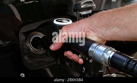 Ravitailler la voiture, la main d'un homme remplit le carburant diesel à la station-service et la pompe à essence remplit la buse de carburant dans le réservoir de la voiture. Banque D'Images