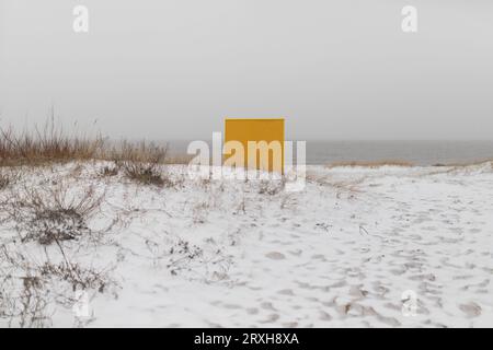 Vestiaire de plage jaune sur plate-forme en bois en hiver. Banque D'Images