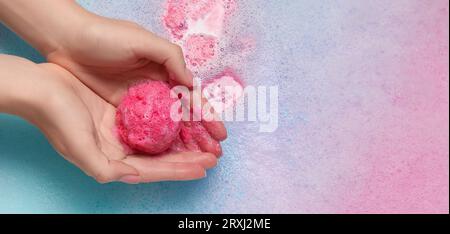 Femme tenant la bombe de bain sur la mousse, gros plan. Conception de bannière Banque D'Images