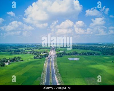 09.16.2023. Raiganj Bengale occidental Inde. Vue aérienne de dessus de la route nationale passant à travers des terres agricoles vertes Banque D'Images