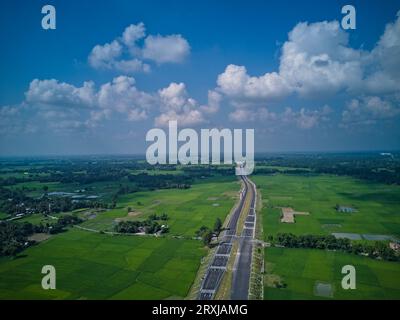 09.16.2023. Raiganj Bengale occidental Inde .vue aérienne de dessus de la route nationale passant à travers des terres agricoles vertes Banque D'Images