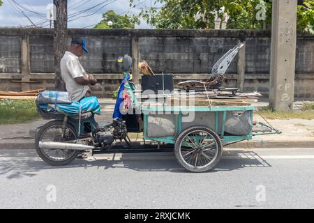 SAMUT PRAKAN, THAÏLANDE, SEP 19 2023, Un homme avec un tricycle chargé de planches usagées parcs dans la rue Banque D'Images