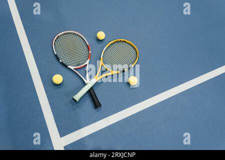 Vue de dessus d'une raquette de tennis, une balle et la ligne blanche sur un court de tennis cyan. concept de sports de tennis Banque D'Images