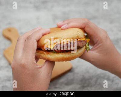 mains prêtes à manger un burger Banque D'Images