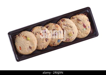 Cookies avec des bonbons au chocolat colorés dans l'emballage en plastique brun isolé sur fond blanc, vue de dessus Banque D'Images