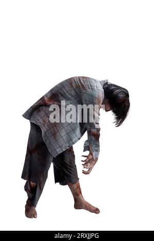 Un zombie effrayant avec du sang et des blessures sur son corps marchant isolé sur un fond blanc Banque D'Images