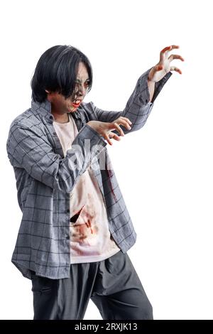 Un zombie effrayant avec du sang et des blessures sur son corps marchant isolé sur un fond blanc Banque D'Images