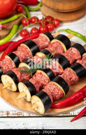 Kebab d'aubergine sur fond de bois. Kebab d'aubergine shish cru aux herbes et épices. Gros plan Banque D'Images