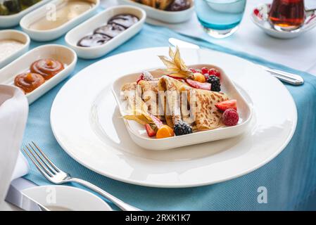 Crêpes sucrées avec des fruits de la forêt à la table du petit déjeuner dans un restaurant gastronomique Banque D'Images