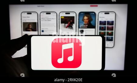 Personne tenant le smartphone avec le logo de la plate-forme de service de streaming Apple Music sur l'écran devant le site Web. Concentrez-vous sur l'affichage du téléphone. Banque D'Images