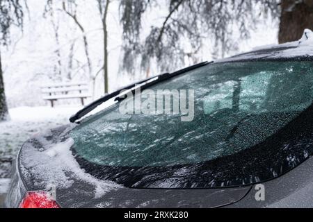 Voiture garée avec de la neige sur le pare-brise. Banque D'Images