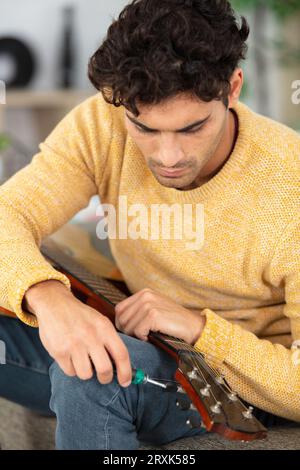 jeune apprenti travaille sur une guitare dans l'atelier Banque D'Images