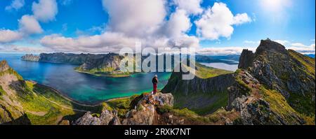 Randonneur se tenant au sommet de la montagne Husfjellet sur l'île Senja en Norvège Banque D'Images