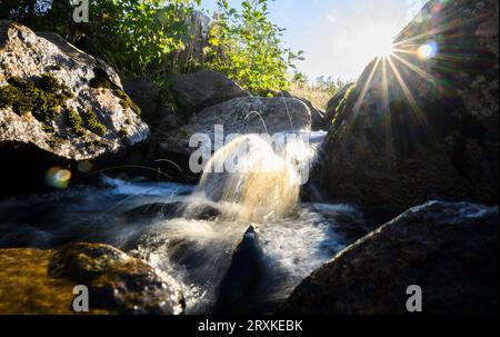 26 septembre 2023, Saxe-Anhalt, Hasserode : l'eau ondule à la lumière du soleil levant dans un ruisseau dans le district de Harz. (Prise avec une vitesse d'obturation lente) photo : Julian Stratenschulte/dpa Banque D'Images