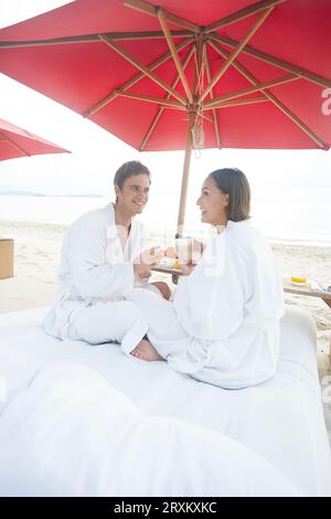 Young couple wearing peignoirs au beach de Ko Samui, Thaïlande Banque D'Images