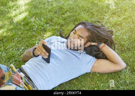 Young man lying in grass Banque D'Images