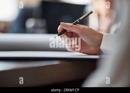 Main de businesswoman signing document Banque D'Images