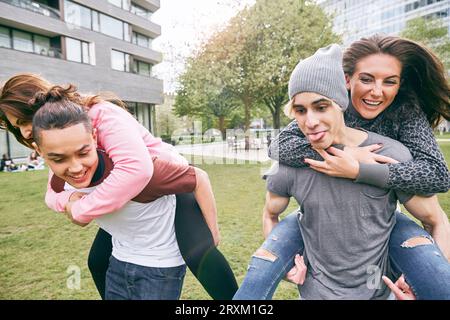 Les couples having piggyback race Banque D'Images