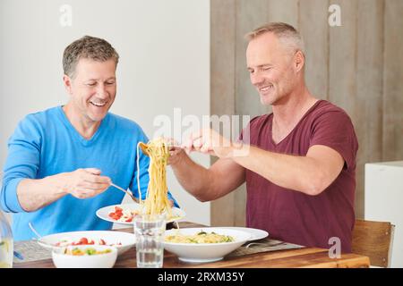 Gay couple eating dinner Banque D'Images
