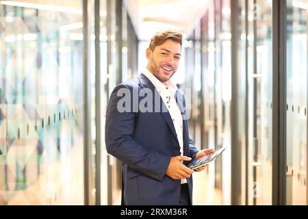 Portrait of young woman holding digital tablet Banque D'Images