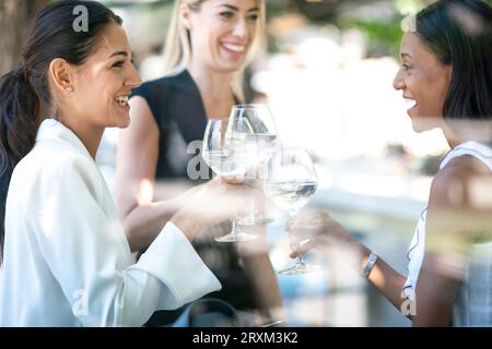 Femmes d'affaires grillant avec des verres à vin Banque D'Images