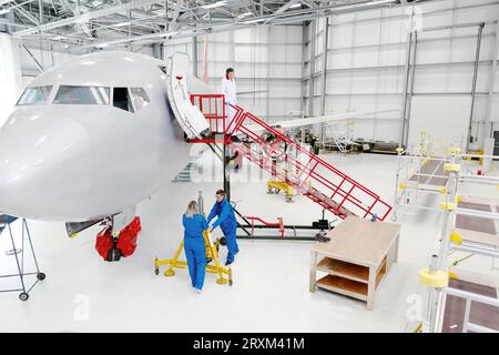 Les travailleurs dans le hangar avion Banque D'Images