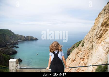 Femme appuyée sur la rampe au-dessus de la plage Banque D'Images