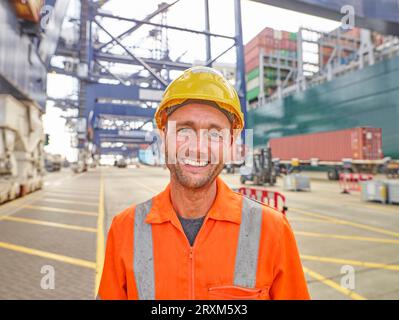 Smiling docker en vêtement réfléchissant et hard hat Banque D'Images