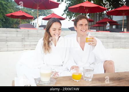 Young couple wearing peignoirs au beach de Ko Samui, Thaïlande Banque D'Images