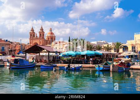 Malte, Marsaxlokk, Europe - 20 octobre 2022 : vue panoramique de la zone portuaire douanière de Malte avec des bateaux de pêche traditionnels en face de la ville Banque D'Images