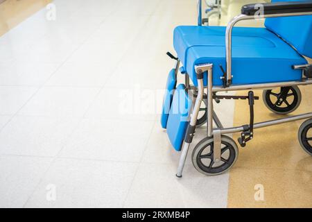 Vue rapprochée du fauteuil roulant rembourré bleu spécialisé avec couloir de l'hôpital Banque D'Images