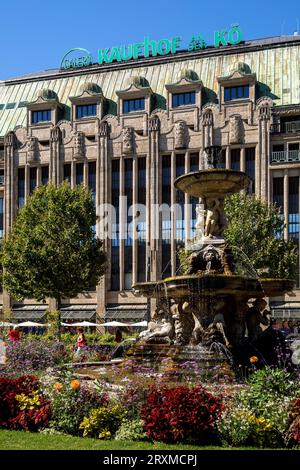 Le grand magasin Kaufhof Galeria an der Koe sur la rue Koenigsallee, place Cornelius avec fleurs et fontaine, Duesseldorf, Rhénanie-du-Nord-Westp Banque D'Images