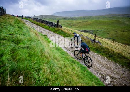 Deux concurrents dans la course de cyclocross 2023 3 Peaks, Yorkshire Dales, Royaume-Uni. Banque D'Images