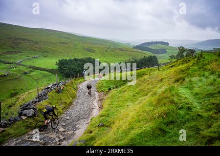 Concurrents descendant Horton SCAR Lane dans la course de cyclocross 2023 3 Peaks, Yorkshire Dales, Royaume-Uni. Banque D'Images