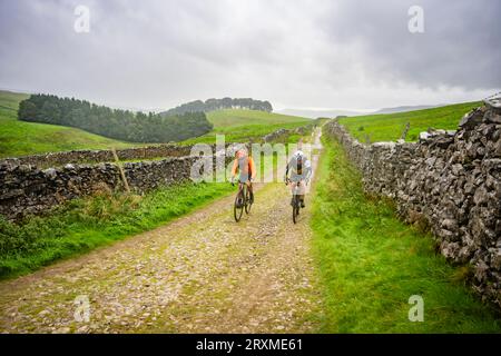 Deux concurrents dans la course de cyclocross 2023 3 Peaks, Yorkshire Dales, Royaume-Uni. Banque D'Images