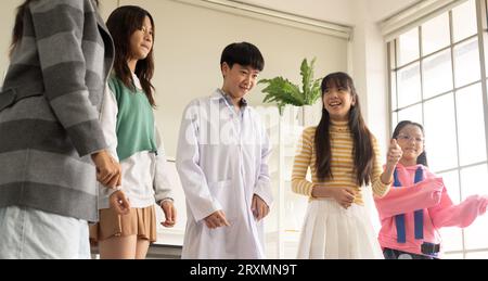 Enfants dansant dans le thème de fantaisie divers. Groupe d'enfants asiatiques aiment danser ensemble dans la soirée après la classe. Banque D'Images