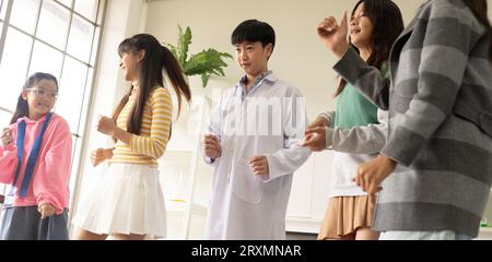 Enfants dansant dans le thème de fantaisie divers. Groupe d'enfants asiatiques aiment danser ensemble dans la soirée après la classe. Banque D'Images