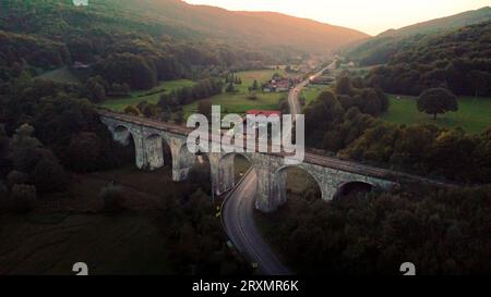 Vieux viaduc de chemin de fer en pierre, viaduc Roumanie, viaduc sur un village Banque D'Images