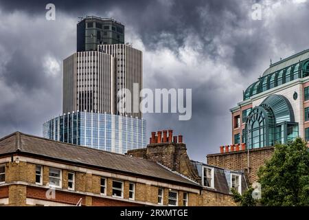 Contre un ciel gris nuageux, la Tour 42 anciennement connue à la Tour NAT Ouest , se dresse au-dessus des bâtiments de Spitalfields, Londres, E1 Banque D'Images