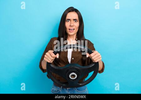 Photo de fille impressionnée choquée habillée chemise marron coincé dans l'embouteillage isolé fond de couleur bleue Banque D'Images