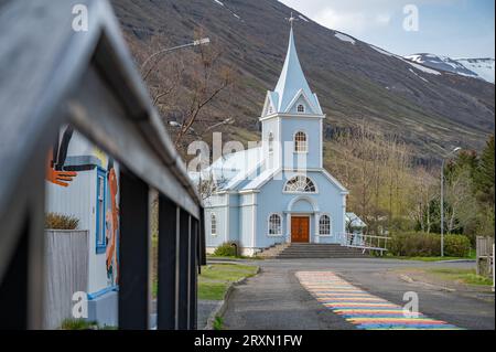 Église avec Rainbow Road à Seydisfjordur, Islande, clôture en bois devant Banque D'Images