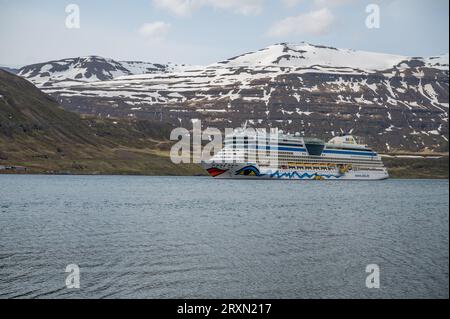 Bateau de croisière aida Bella au fjord de Seydisfjordur, Islande, vue latérale avec chaîne de montagnes enneigées en arrière-plan Banque D'Images