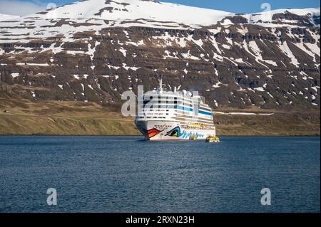 Aida Bella bateau de croisière au fjord de Seydisfjordur, Islande, vue de la distance avec des montagnes de neige en arrière-plan Banque D'Images