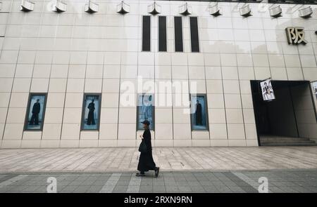 Une femme japonaise passe devant la façade d'un magasin de mode haut de gamme à Ginza, Tokyo, Japon. Banque D'Images