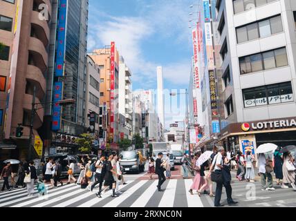 Les gens marchent sur une souche piétonne croisant dans le quartier commerçant d'Ikebukuro, Tokyo, Japon Banque D'Images