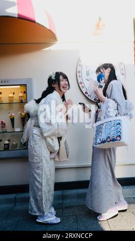 Deux japonaises vêtues de kimonos rient de photos sur un smartphone à Asakusa, Tokyo, Japon Banque D'Images